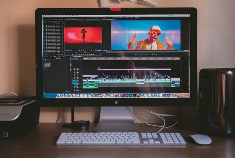 How to Share Videos on Google Drive (Full Guide) Video editing software open on a large monitor showing a colorful video timeline, representing video file sharing and management. Photo by Vanilla Bear Films on Unsplash.