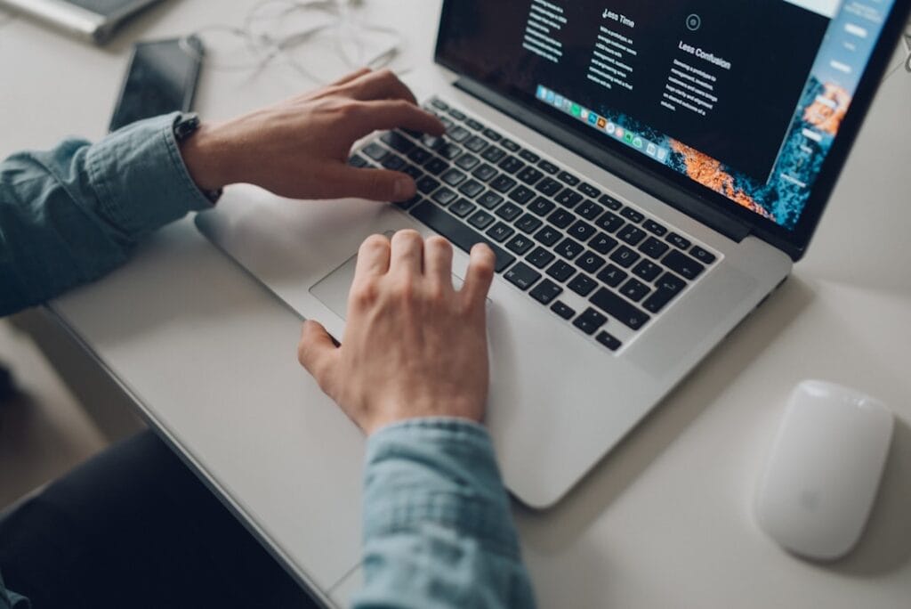 How to Share Videos on Google Drive (Full Guide) Hands typing on a MacBook laptop, generating a direct download link for a Google Drive video file.