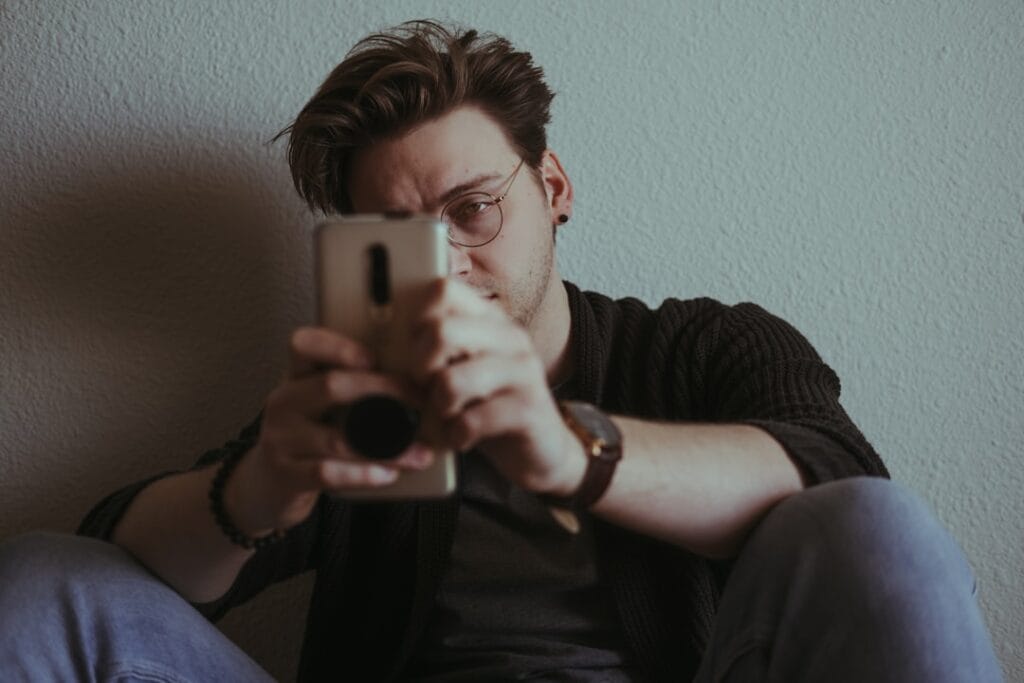 Person squinting at a smartphone, illustrating common video playback issues on mobile browsers